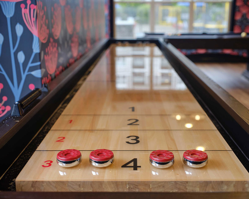 Indoor shuffleboard table with red sliders