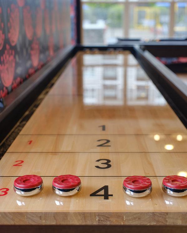 Indoor shuffleboard table with red sliders