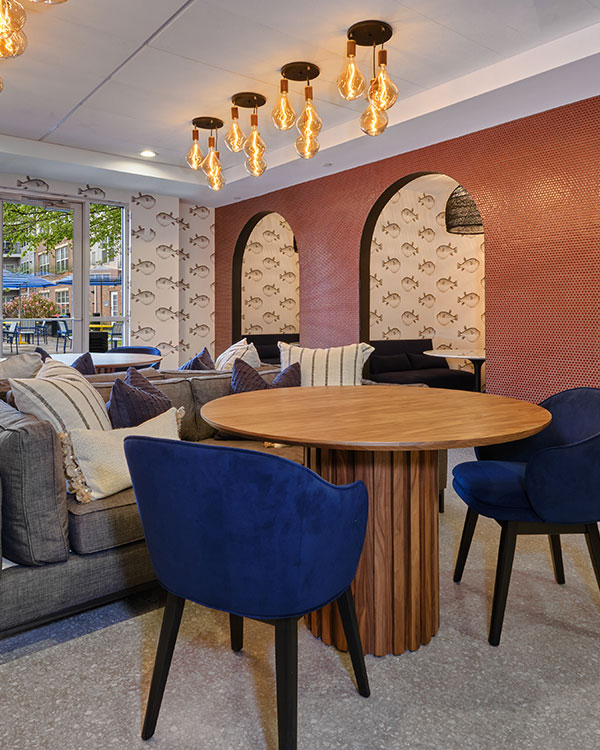 Stylish lounge area with modern lighting, cozy seating, and arched wall decor