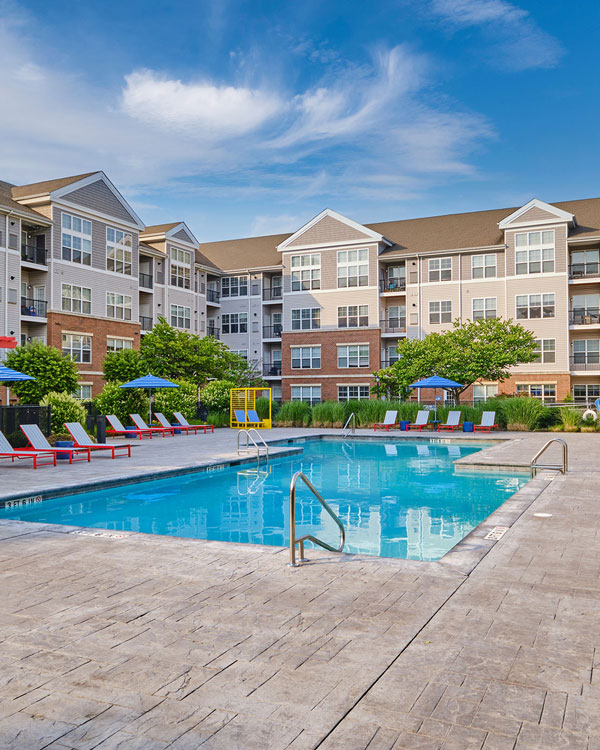 Apartment pool area with red pergola and furniture