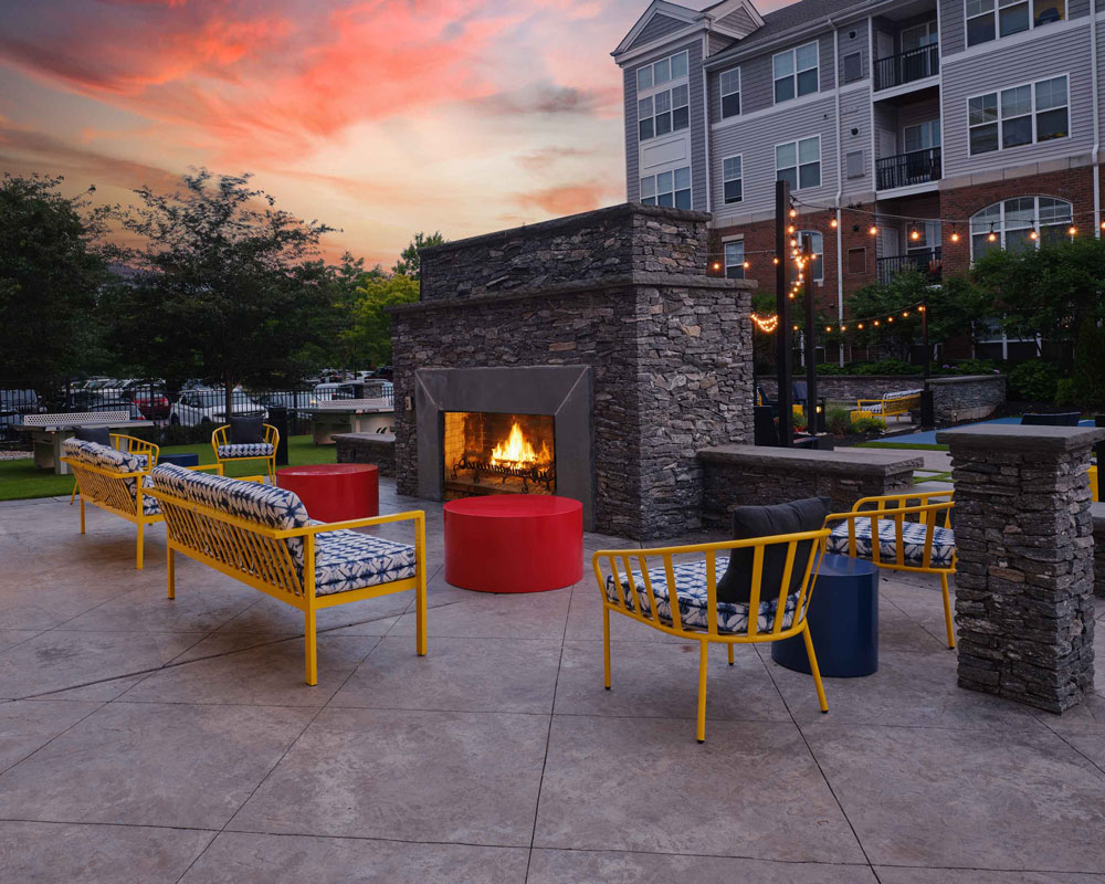 Outdoor sitting area with yellow furniture and fireplace