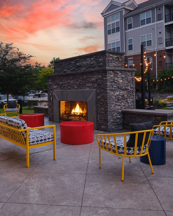 Outdoor sitting area with yellow furniture and fireplace